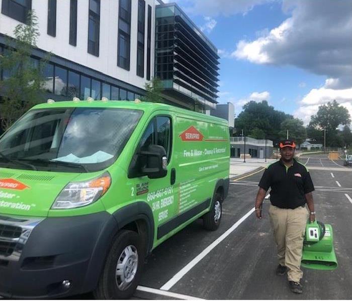 Employee carrying equipment by a SERVPRO van